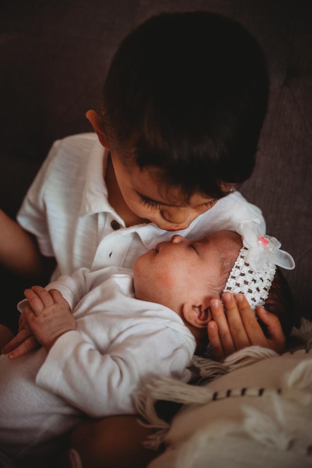 Best Maternity and Newborn Photographer Washington DC Maryland Northern Virginia - toddler boy kissing his newborn sister on the nose while cradling her head