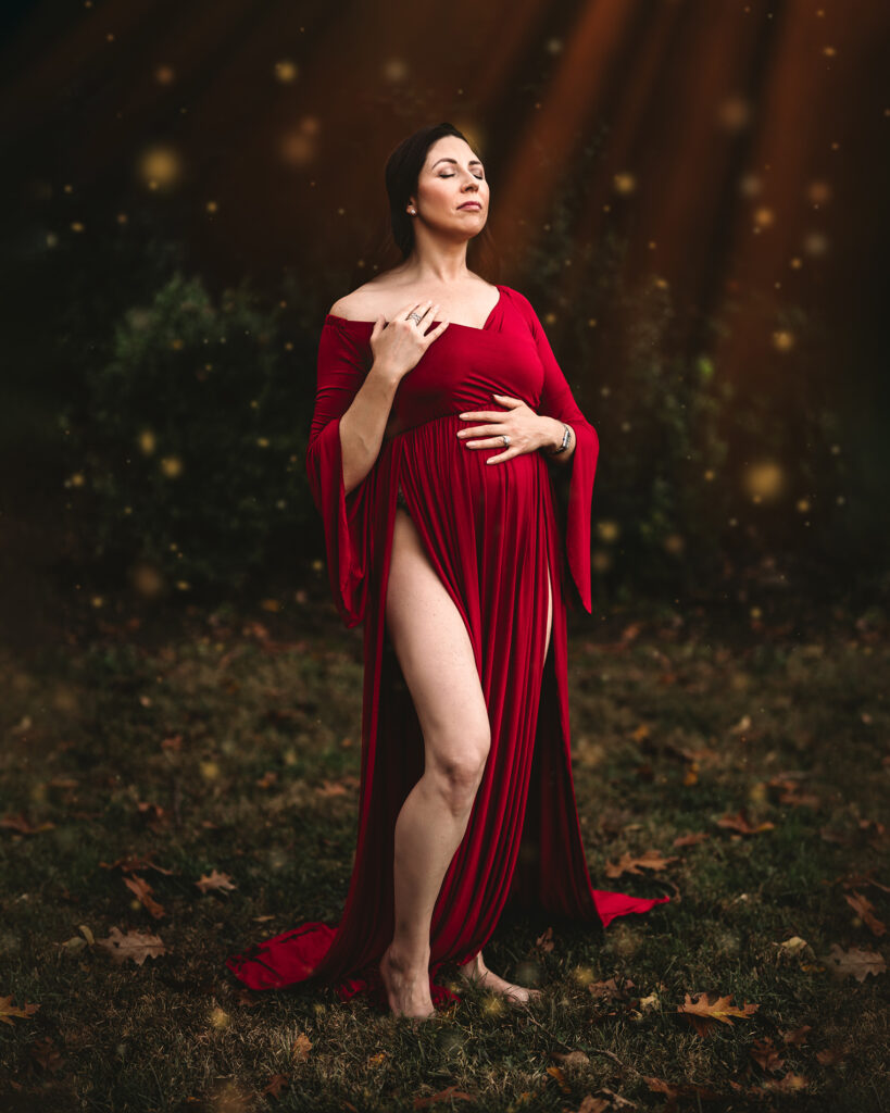 pregnant woman in deep red dress with leg showing photographed by maternity photographer allison corinne